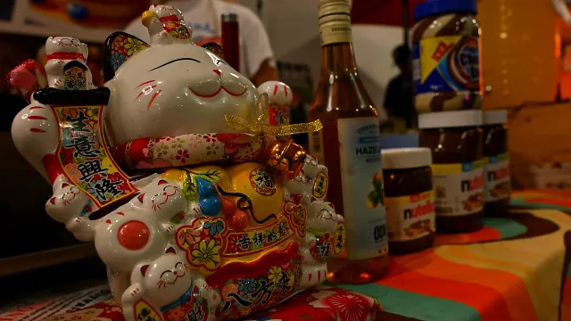 Ceramiczny kot maneki-neko na stoisku